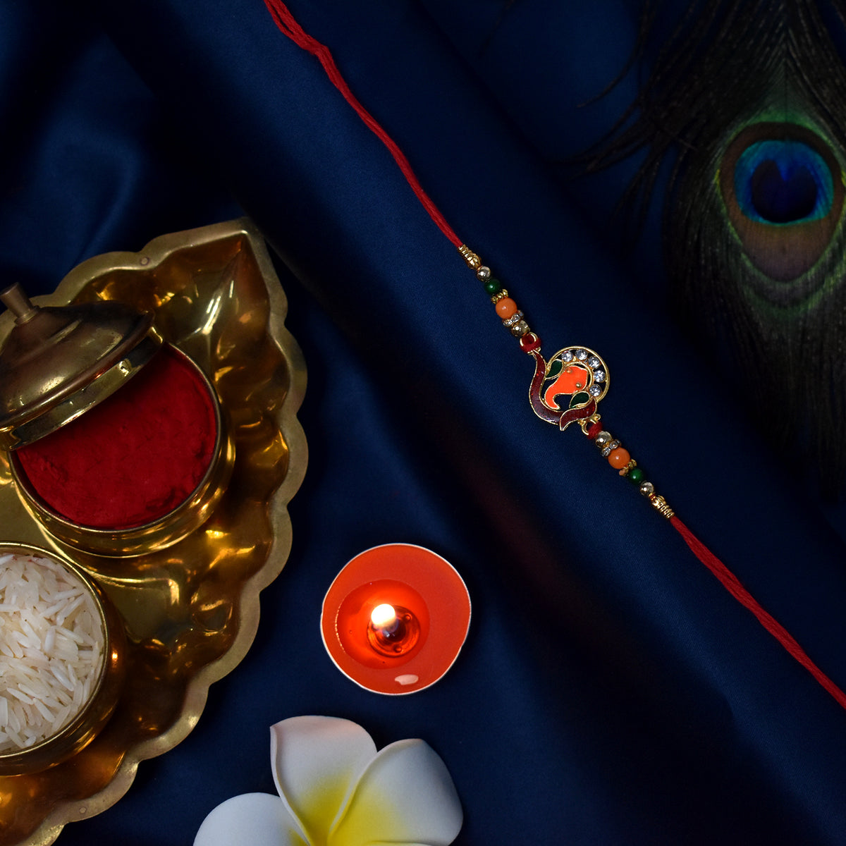 Golden Ganesha Rakhi With Red-green Beads And Stone Detailing